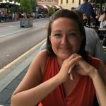 A picture of me smiling in an orange dress sitting at a table in Fremantle